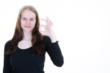 Obraz premium Attractive woman posing in studio showing ok sign on copy space white background