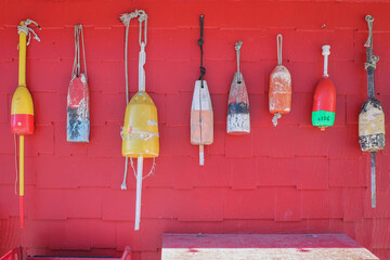 Buoys moorings hanging on a red wall.