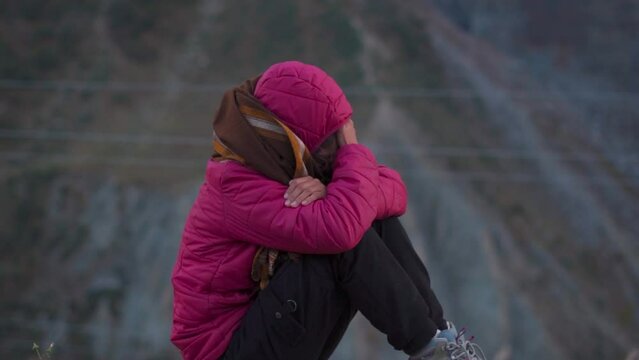 Sad frustrated young Indian woman sitting alone and cope up  pain and headache. Upset lonely thoughtful lady feeling depressed, anxious, worried. Loneliness concept. Panic attack in young female