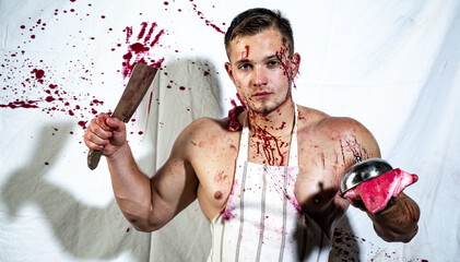 Brutal butcher, handsome serious male model. Shirtless butcher with wearing bloody apron posing with fresh raw meat. - obrazy, fototapety, plakaty