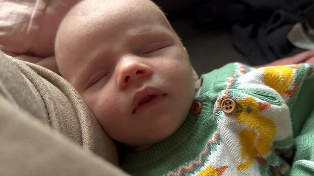Cute Newborn Baby with closed eyes sleeping during sunlight, wearing cute duck shirt, close up slow motion