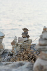 Rock balance. Stones placed one on top of the other, on the beach. The sea in the background