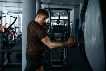 Young professional boxer training with punching bag