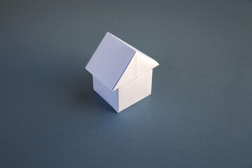 White paper house origami isolated on a grey background