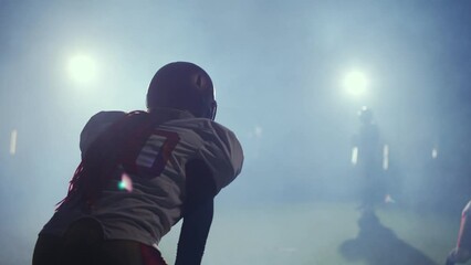 Cinematic, american football, back view of the player in protective gear preparing throw the ball to a teammate, 4k super slow motion.