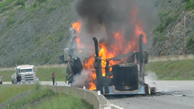 An 18 Wheeler Semi Tractor Truck Burns Uncontrollably On A Forested Highway