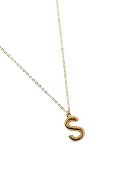Detail shot of a metal golden necklace made out of a chain with a dangling pendant with a letter "S". The elegant necklace with a lobster clasp is isolated on the white background.