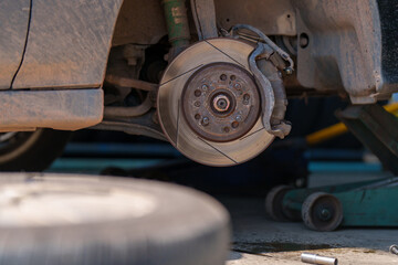 auto mechanic repairman changing wheel and tire in a workshop	