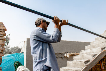 laborer carrying a steel beam
