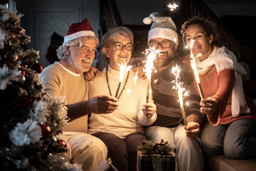 Multigenerational family group celebrates Christmas and New Year at home with twinkling lights.