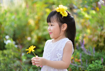 backlight Outdoor portrait of a cute 5 year old Asia little girl 