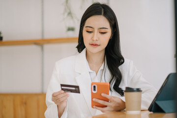 Happy asian Business woman pay online using mobile phone at the office.