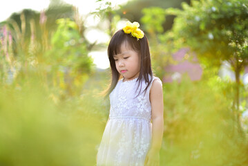 backlight Outdoor portrait of a cute 5 year old Asia little girl 