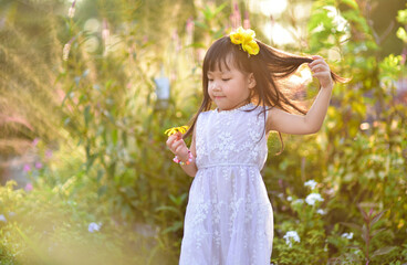 backlight Outdoor portrait of a cute 5 year old Asia little girl 
