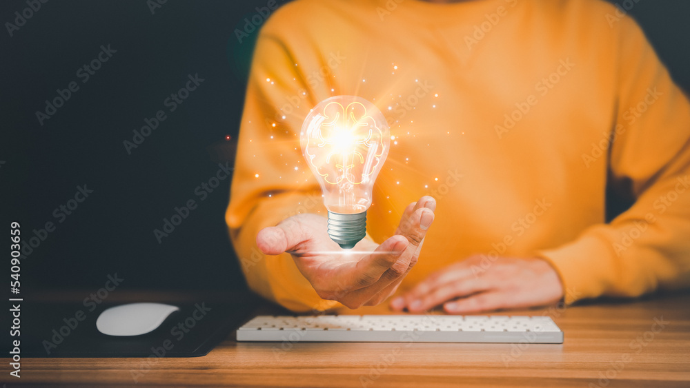 Aufkleber man holding a glowing abstract light bulb with a computer keyboard on the table. business problem so
