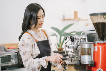 Opening a small business, AHappy Asian woman in an apron standing near a bar counter coffee shop, Small business owner, restaurant, barista, cafe, Online, SME, entrepreneur, and seller concept