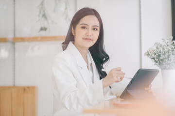Portrait of smiling beautiful business asian woman working in modern office desk using tablet laptop computer, Business people employee freelance online marketing e-commerce telemarketing concept.