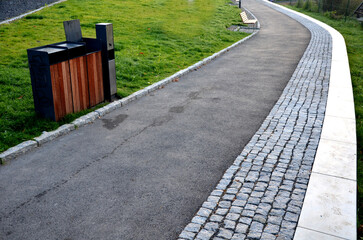 rows of reddish wood benches on their paneling under the benches is a rectangle of concrete...