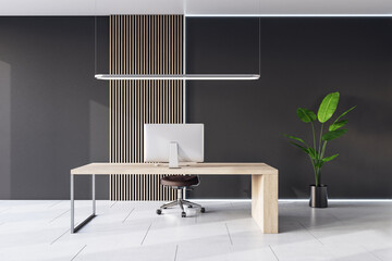Front view on light wooden work table with modern computer on ceramic tiles floor with green plant in black flowerpot in stylish cabinet with dark wall background. 3D rendering