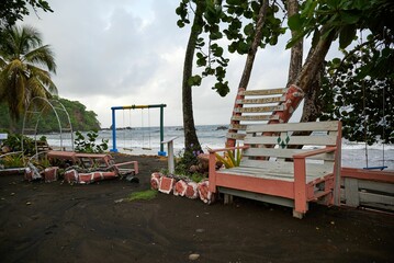 Simple swing with wooden chairs on the shore of a tropical island with low tides in the sea