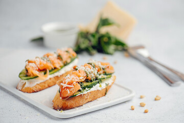 Close up of two bruschetta on a cutting board. Partially blurred