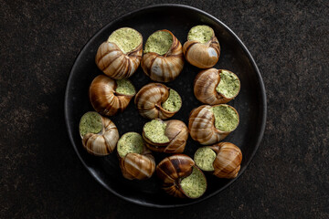Snails with parsley butter, Bourgogne Escargot Snails on plate. Delikatese food. Top view.