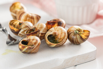 Snails with parsley butter, Bourgogne Escargot Snails on cutting board. Delikatese food.
