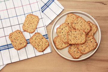 dry square diet crackers with black cumin seeds and quinoa in a glass plate