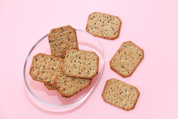 dry square diet crackers with black cumin seeds and quinoa in a glass plate