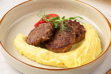 Portion of russian beef cutlets with mashed potato and herbs