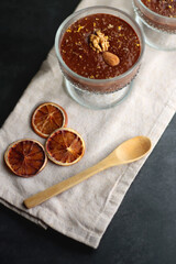 Bowl of homemade chocolate chia pudding, made with dark chocolate, chia seeds, orange juice and plant based milk. Selective focus.
