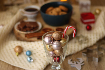 Various Christmas decorations, cup of tea or coffee, sweets, small presents, knitted blanket and candles. Selective focus.