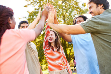 Group of friends as a team in nature at the high five
