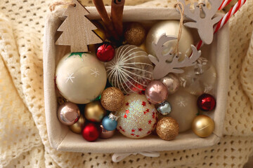 Basket with various Christmas ornaments and knitted blanket. Top view.