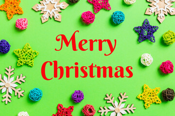 Fototapeta na wymiar Merry Christmas text. New Year decorations on green background. Festive stars and balls. Merry Christmas concept with empty space for your design