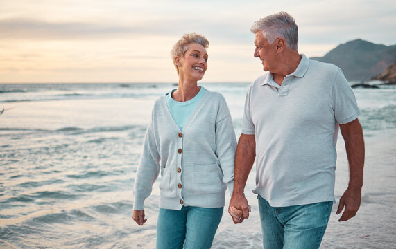 Beach, holding hands and senior couple with sunset for outdoor wellness, retirement holiday and outdoor date mock up sky. Happy elderly people, or old man and old woman walking by sea or ocean water