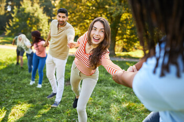 Fototapeta premium Young people stand hand in hand in a meadow