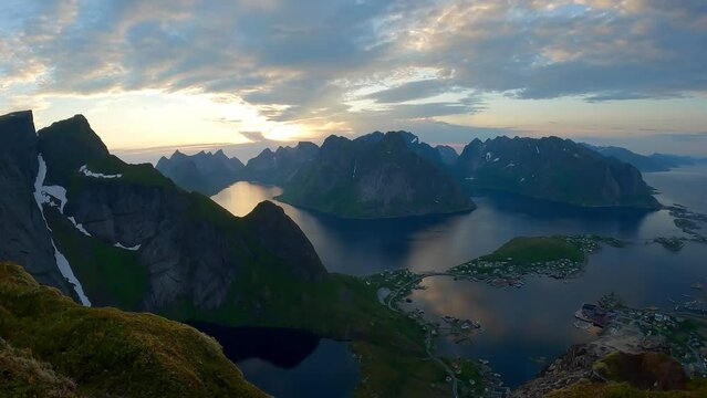Beautiful time lapse from the summit of a mountain of clouds streaming by over peaks in the famous Reinebringen Hike during the midnight sun, Norway