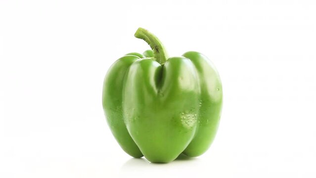 whole green fresh bell pepper capsicum in white background rotating side shot
