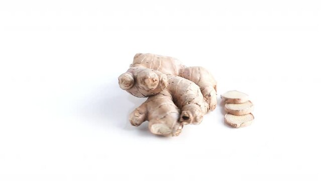 Top shot a hand of ginger and slices rotating 360 degrees on a white background top shot
