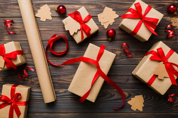 Fototapeta na wymiar Christmas kraft gifts box with ribbon on colored background. Cozy Christmas still life, birthday or new year