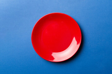Top view of isolated of colored background empty round red plate for food. Empty dish with space...