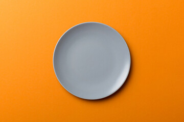 Top view of isolated of colored background empty round gray plate for food. Empty dish with space for your design