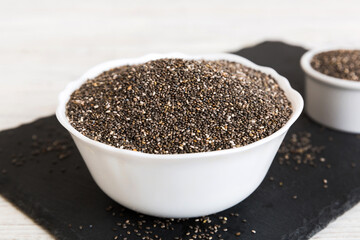 Fototapeta na wymiar Chia seeds in bowl on colored background. Healthy Salvia hispanica in small bowl. Healthy superfood