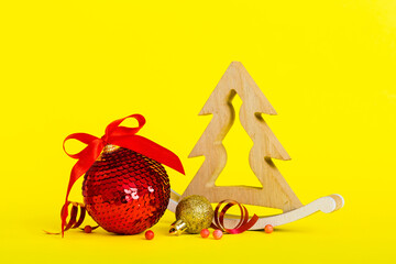 Christmas ball with decorative wooden tree on colored background. decoration bauble with ribbon bow with copy space