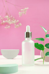 White cosmetic bottle and flowers. Bottle of cosmetic serum or essential oil. Minimal background layout