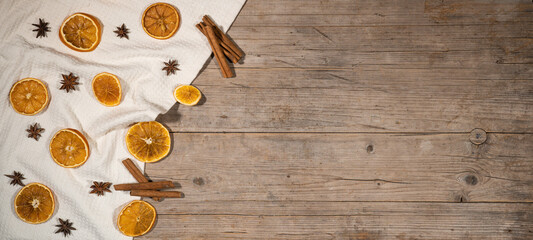 christmas winter food advent background - christmas scent, dried orange slices, cinnamon sticks and cloves, on rustic wooden table, top view