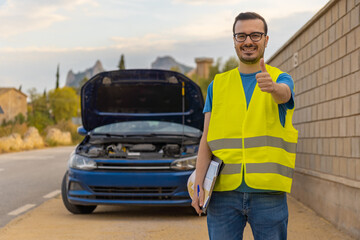 Técnico en primer plano, con expresión alegre y pulgar hacia arriba, y de fondo coche reparado.