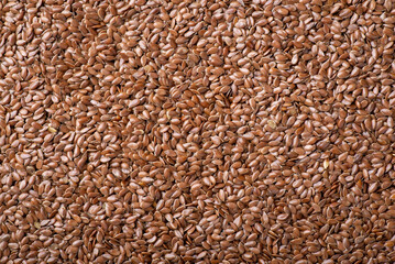 Background of linen grain. Top-down flat shot of brown linen seeds used in culinary