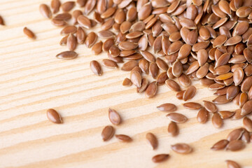 Close up shot of linen grain on the wooden table. Linen seeds used in culinary